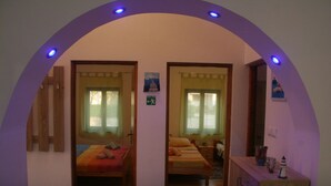 Una habitación con dos camas, un aparador de madera y un espejo.