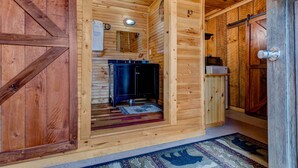 A wooden cabin interior with a kitchen area, including a sink and cabinets. -  TURNING LEAF•Cozy Cabin in the RRG• Couples Retreat (Pine Ridge)