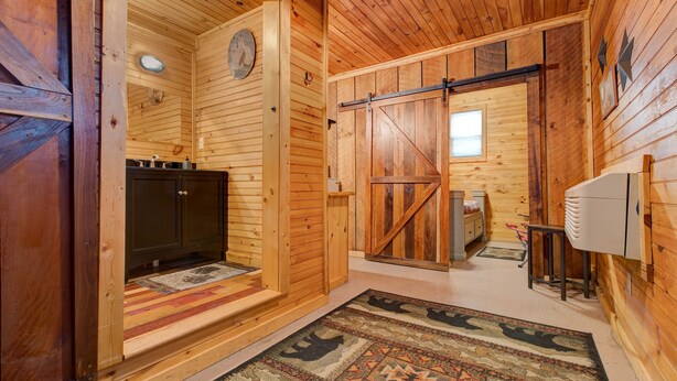 A wooden interior with a kitchen area, a sliding door, and a patterned rug. -  TURNING LEAF•Cozy Cabin in the RRG• Couples Retreat (Pine Ridge)