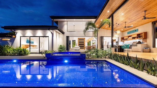 A modern house with a swimming pool, a dining area, and a kitchen. - Eden Roc Villa Luxury 5BR in Hacienda Pinilla (Tamarindo)