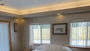 Une chambre à coucher avec un lit, une fenêtre et un tableau au mur.