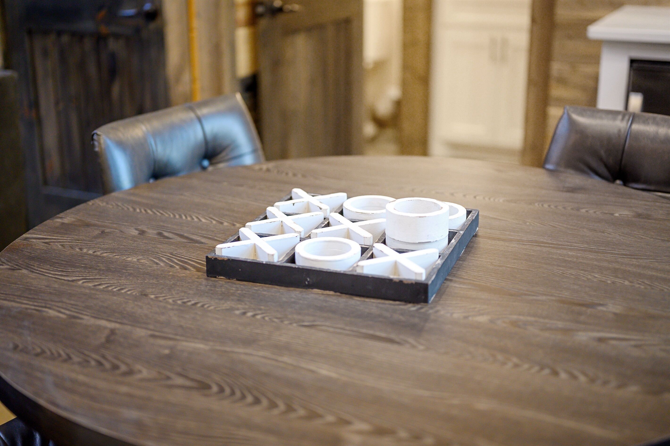 A round wooden table with a tray of white cups and a black tray.