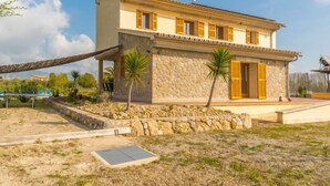 A two-story house with a stone facade, yellow shutters, and a solar panel on the roof. - Son Bordoi by Interhome (Moscari)