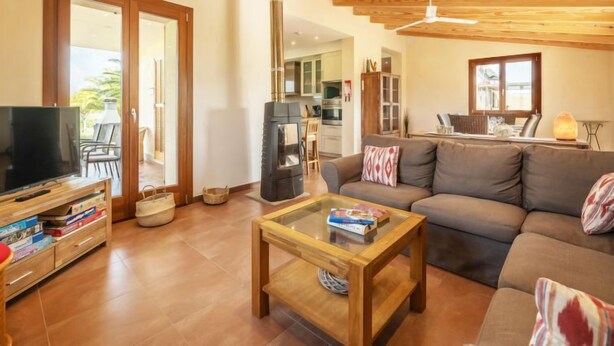 A living room with a sofa, a coffee table, a television, and a fireplace. - Son Bordoi by Interhome (Moscari)