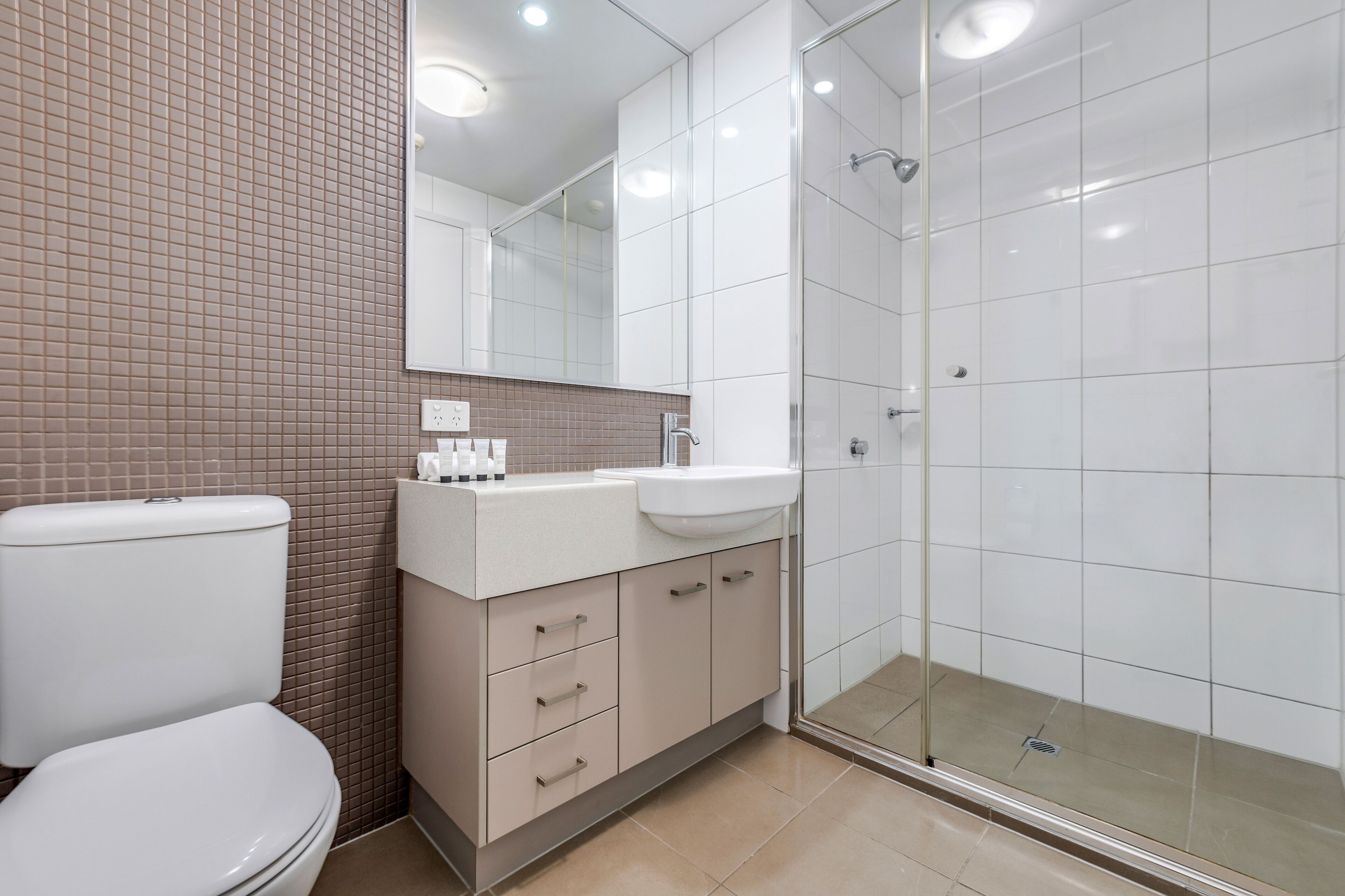 A modern bathroom with a toilet, sink, and shower.