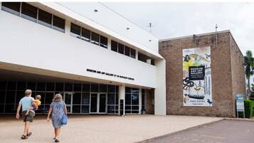 A building with a sign reading "Museum and Art Gallery Northern Territory" and a banner advertising free entry.