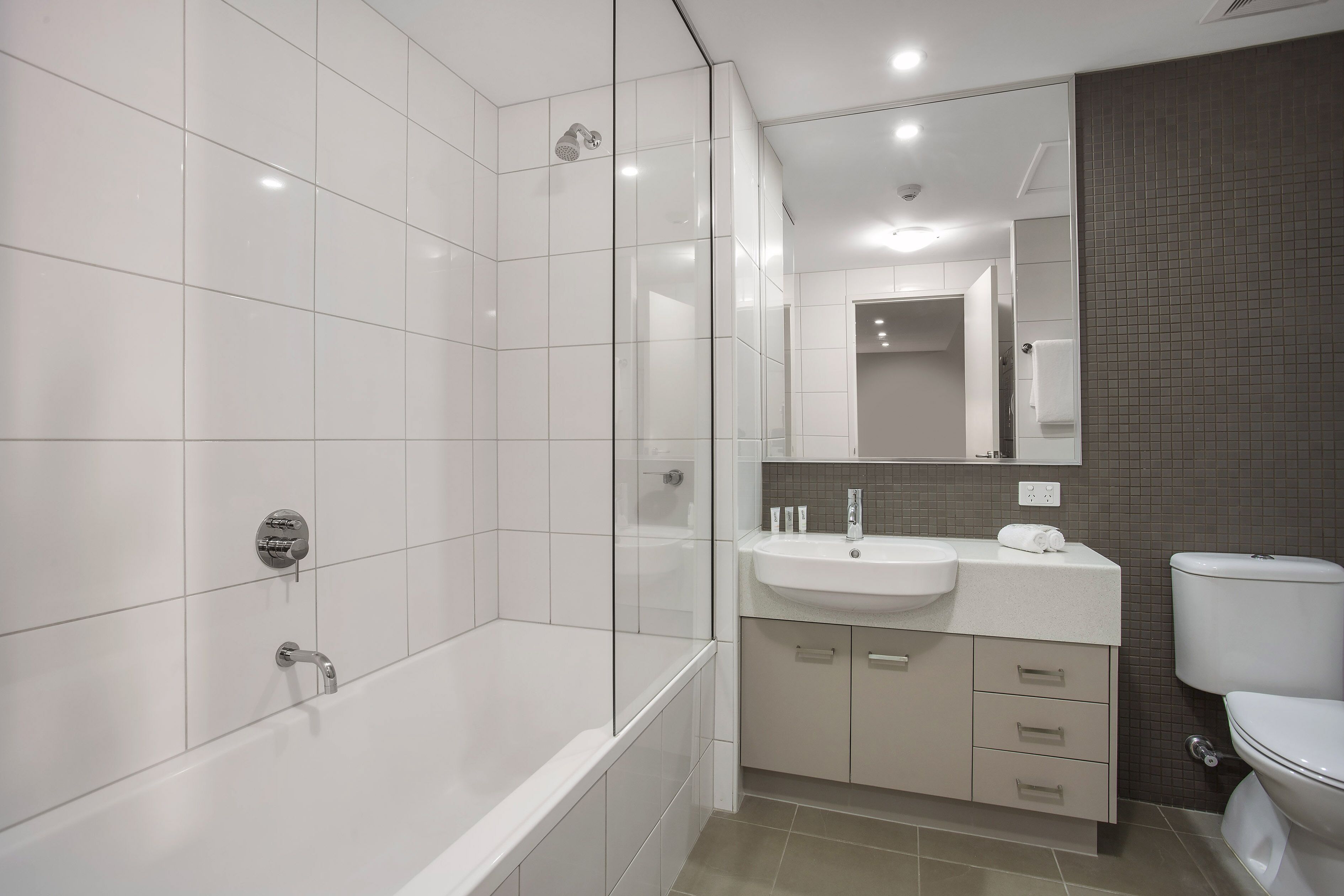 Un baño moderno con bañera, lavamanos e inodoro.