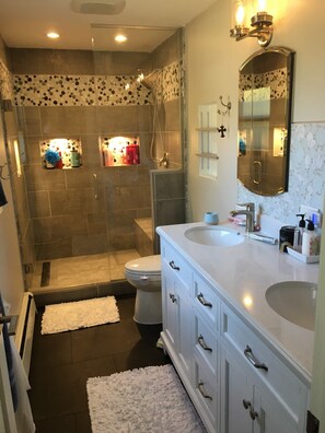 Bañera con ducha, toallas, jabón, papel higiénico