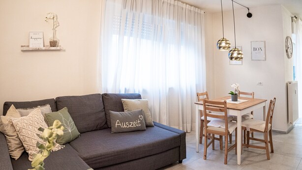A modern living room with a sofa, a dining table, and a coffee table.