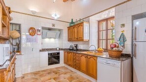 Una cocina con armarios de madera, horno empotrado, fregadero y refrigerador.