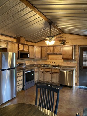 A kitchen with wooden cabinets, stainless steel appliances, and a ceiling fan. - House near  Sardis Lake , golf course and Oxford, MS  (Sardis)