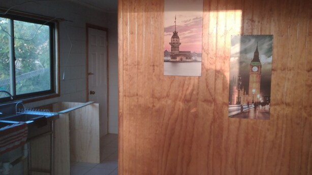 Eine Küche mit Holzwandverkleidung, einem Fenster und einem Spülbecken.