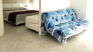 Una habitación con una cama, un sofá y una pared decorada con un cuadro y un adorno.