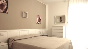 A bedroom with a bed, a dresser, and a mirror.