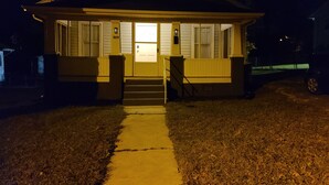 A two-story house with a front porch, a visible door, and a number '809' on the wall.