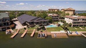 A hotel with a swimming pool, docked boats, and a view of the surrounding landscape.