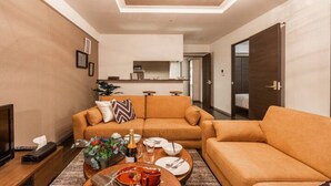 A modern living room with a sofa set, a coffee table with drinks, and a TV. - Glow (Otaru)
