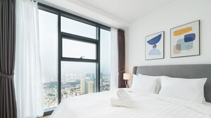 A hotel room with a large window, a neatly made bed, and two abstract art pieces on the wall. - Hoasun Skyview Sunwah Pearl (Ho Chi Minh City)