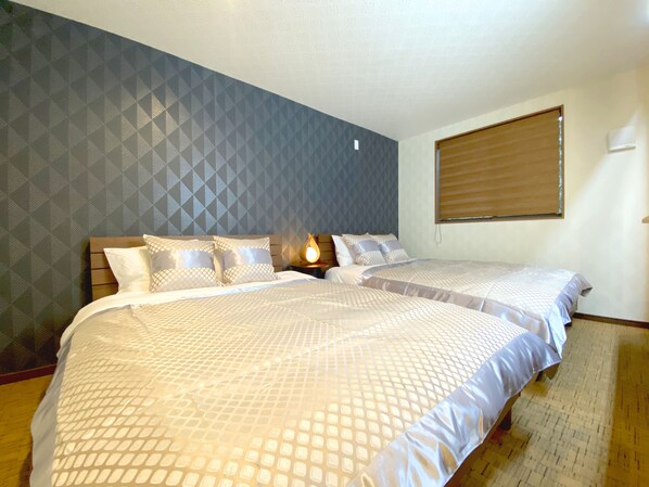 A double room with two beds, a patterned wall, and a window with blinds. - Diamond YU (Fujikawaguchiko)