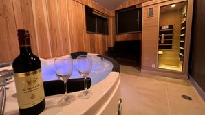 A wooden interior with a hot tub, two wine glasses, and a bottle of wine. - Diamond YU (Fujikawaguchiko)