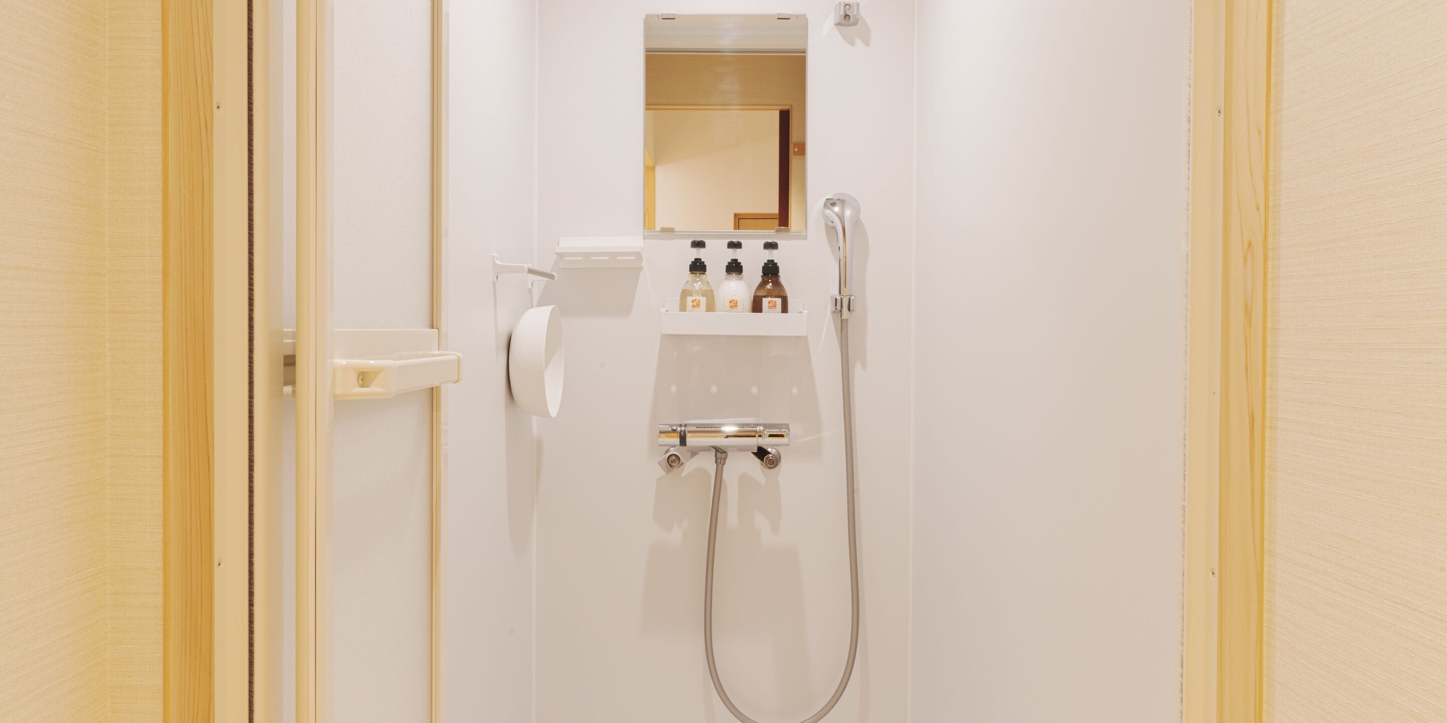Un baño con inodoro, lavabo, espejo y ducha.