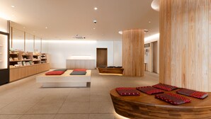 A modern spa room with a reception desk, seating area, and wooden accents. - Hotel Tenpyo Naramachi (Nara)