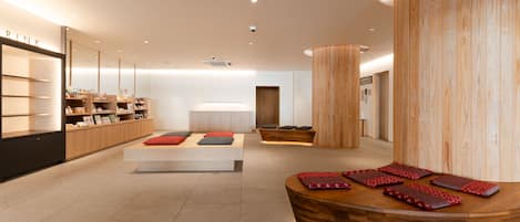 A modern spa room with a reception desk, seating area, and wooden accents.