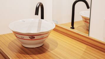 A bathroom sink with a mirror and a wooden countertop.