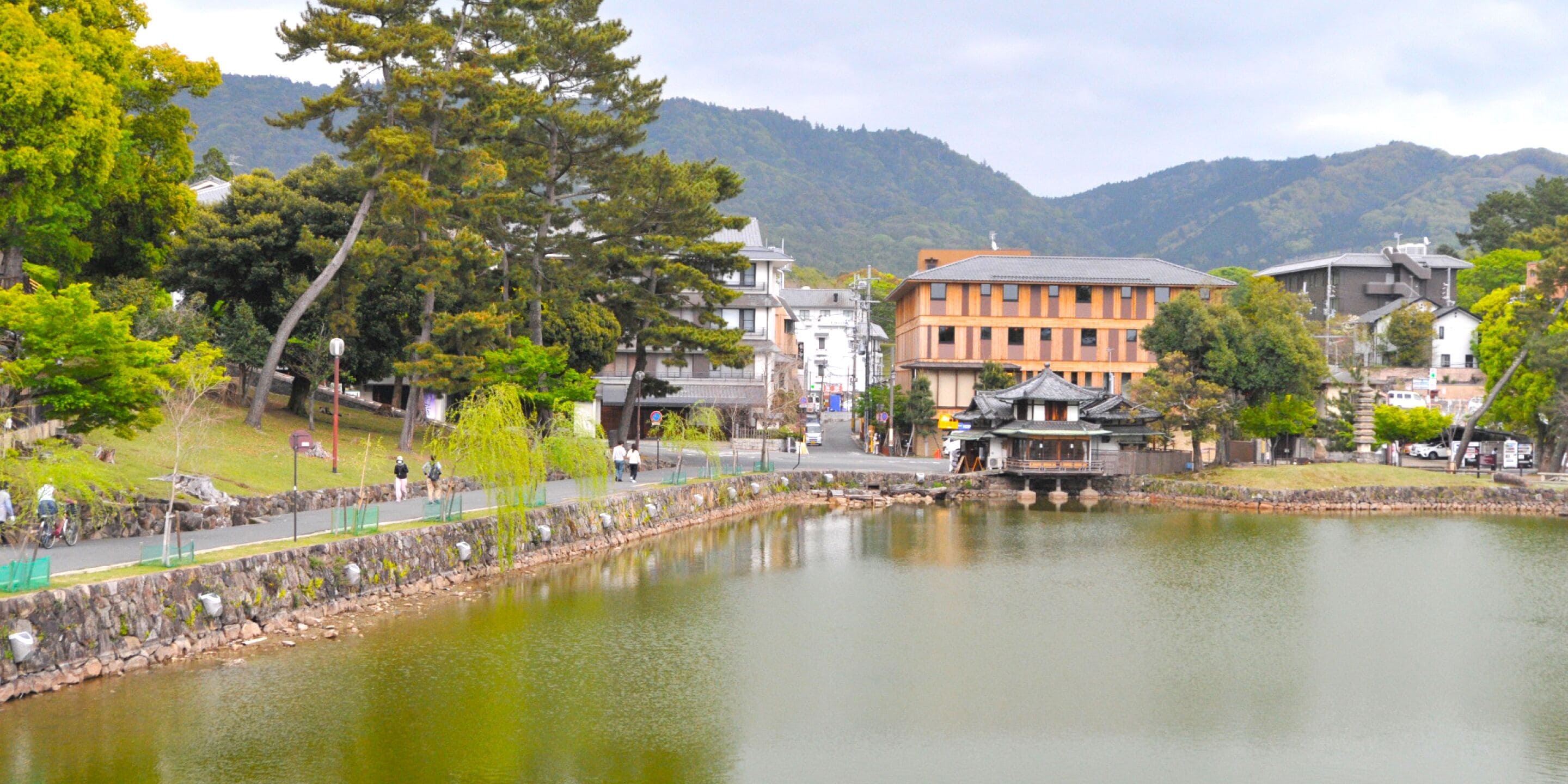 Une vue sur le lac, agrémentée d’une architecture japonaise traditionnelle, d’un sentier de pierre et d’un petit pavillon.