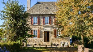 A stone house with a stone facade, wooden shutters, and a stone roof. - Sénezergues Garden Hideaway (Sénezergues)