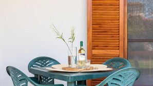 A table with a bottle of wine, two glasses, and a small plant. - Holiday resort, Budoni (Budoni)