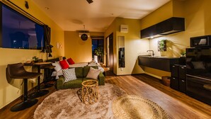 Ein kompakter Wohnbereich mit Küchenzeile, Essbereich und Sitzecke mit Sofa und Stühlen.