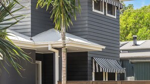 A modern two-story house with a covered patio, a garage, and a striped awning. - Elua Beach House - Perfect Location - Perfect Space! (Byron Bay)