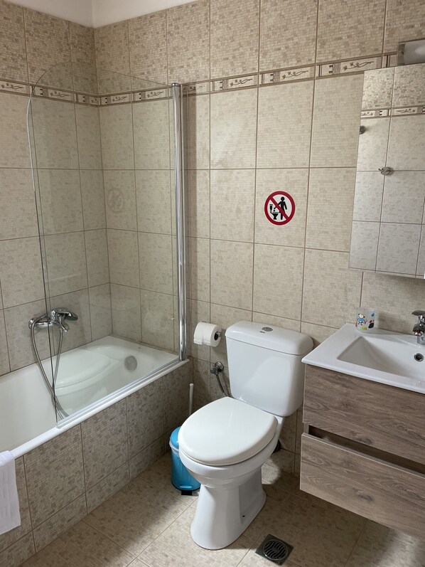 A bathroom with a bathtub, toilet, and sink. - Monolithos Villas (Andros)