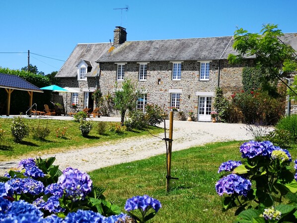 A stone building with a covered patio and outdoor seating.