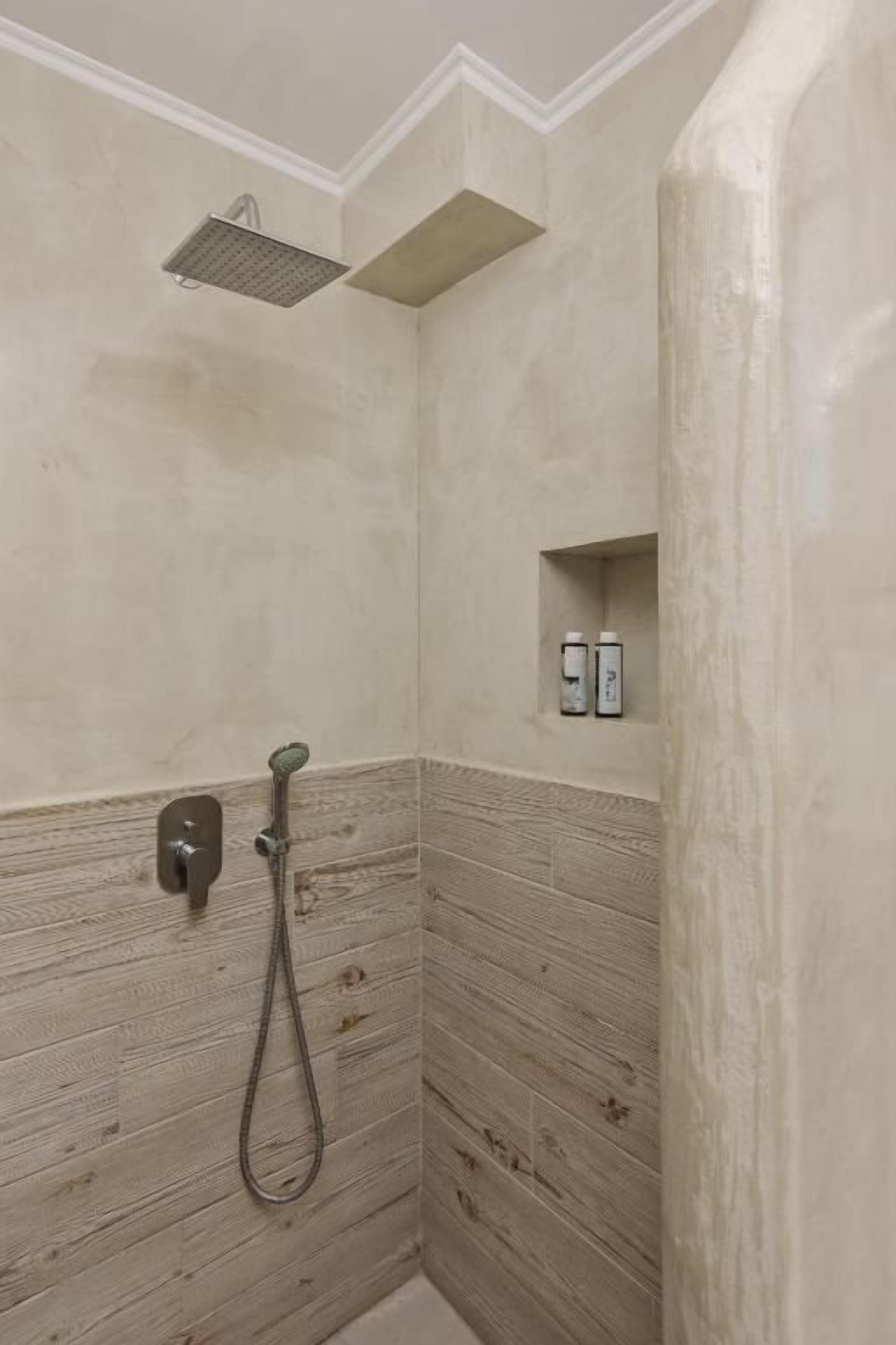 Ein Badezimmer mit Dusche, Handtuchhalter und Seifenspender.