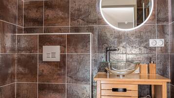 Une salle de bain moderne avec un lavabo en verre, un meuble-lavabo en bois et des toilettes blanches.