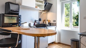 Una cocina moderna con horno empotrado, una mesa de comedor con sillas y una ventana que ofrece vistas al exterior.