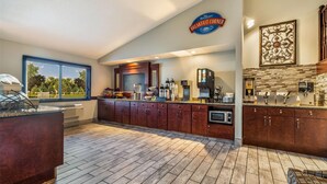 A modern kitchen with a breakfast bar, a coffee machine, and a sign for the breakfast corner. - Baymont By Wyndham Bloomington Msp Airport (Richfield)