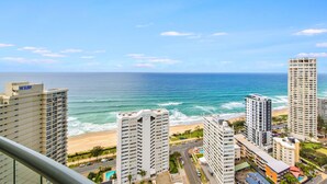 A high-rise hotel overlooking a beach with ocean views.