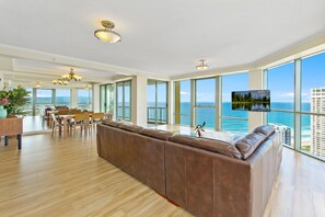 Relax in this stylish living area with a large sofa, dining table, and flat-screen TV.