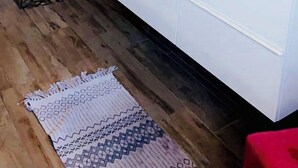 Un bagno moderno con box doccia in vetro, un mobile lavabo bianco con un grande specchio e un tappeto decorativo sul pavimento.