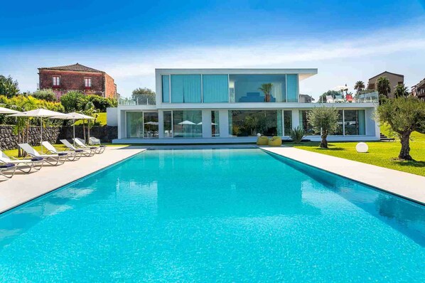 Guests can relax by the pool surrounded by lush greenery and lounge in comfort.