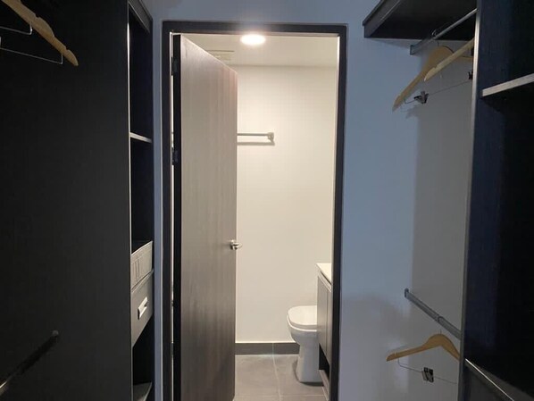 A narrow hallway leading to a bathroom with a toilet and a towel rack. - Costa Rica, Mountain View,National Stadium,restaurants,banks,supermarkets,stores (San Jose)