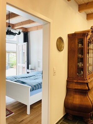A bedroom with a bed, a wooden cabinet, and a window with curtains.