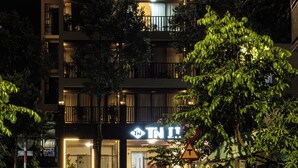 A multi-story hotel with illuminated signage, balconies, and a well-lit entrance. - Tuan Ninh Hotel 2  (Ho Chi Minh City)