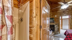 L’intérieur d’un chalet en bois comprend une salle de bain, une cheminée et un coin repas.