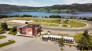 An aerial view of a racetrack with a building labeled "BIRI Trarbane" and a lake in the background.