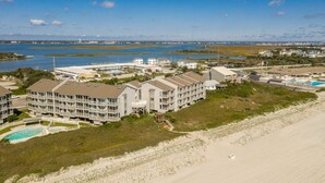 A coastal hotel with multiple buildings, a beach, and a marina.