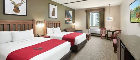 A hotel room with two beds, a desk, a chair, and a TV.